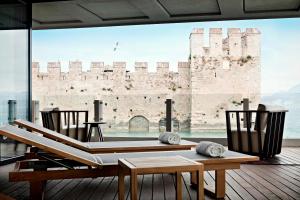 a room with a table and chairs and a large window at Grand Hotel Terme Sirmione in Sirmione