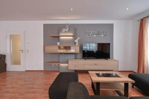 a living room with a couch and a tv at Haus San Marco in Füssen