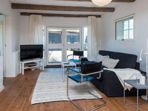 Holiday Home Varnæshoved في أبينرا: غرفة معيشة مع أريكة وتلفزيون