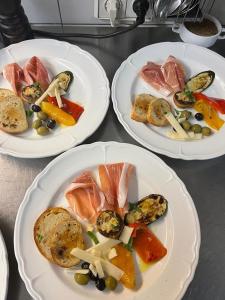 tres platos de comida en una mesa con platos de comida en Hotel Allegra, en Heinsberg