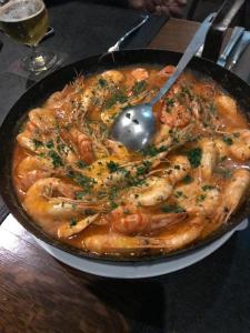 a pan of food with shrimp and a spoon at Hotel Allegra in Heinsberg