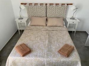 a bedroom with a bed with two tables and two pillows at Apartamento MIRI in Costa Teguise