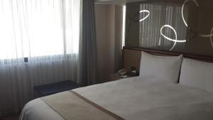 Postel nebo postele na pokoji v ubytování Kaohsiung Chateau de Chine Hotel