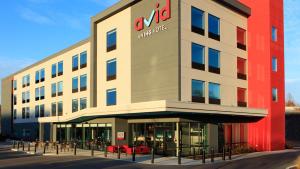 avid hotels - Orlando International Airport, an IHG Hotel في أورلاندو: مبنى مع مكتب أمازون في الأمام