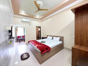 a bedroom with a bed and a ceiling fan at Aappayan Guest House & Restaurant in Bolpur