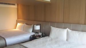 Postel nebo postele na pokoji v ubytování Kaohsiung Chateau de Chine Hotel