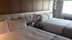 Postel nebo postele na pokoji v ubytování Kaohsiung Chateau de Chine Hotel