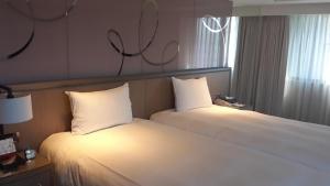 Postel nebo postele na pokoji v ubytování Kaohsiung Chateau de Chine Hotel