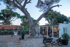 a house with a large tree in the yard at A House in Estoril - Adults Only in Estoril