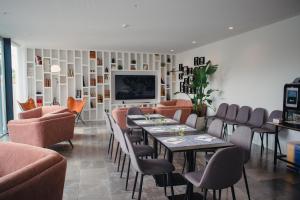 a restaurant with tables and chairs and a television at A House in Estoril - Adults Only in Estoril