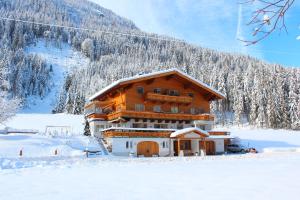 un gran edificio en la nieve frente a una montaña en Ferienwohnung Schnell en Flachau