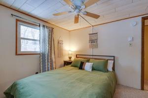 1 dormitorio con 1 cama verde y ventilador de techo en 2Bd Lake Access Bungalow with Hot Tub in Locust Lake, en Locust Lakes Village