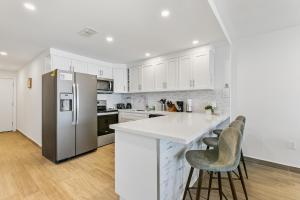 a kitchen with white cabinets and a refrigerator at Fully Renovated Beachfront Villa with Picture Perfect Ocean Views in South Padre Island