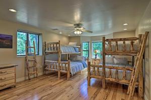 a bedroom with bunk beds and a ceiling fan at Serene Lakeside Cabin with Decks and Edler Lake Views! in Pinetop-Lakeside