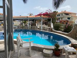 uma piscina num resort com cadeiras e uma mesa em Hotel NHATERRA em Santa Maria
