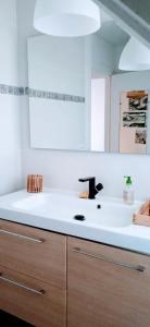 eine weiße Küche mit einem Waschbecken und einem Spiegel in der Unterkunft Maison rénovée avec jardin proche grande plage in Quiberon