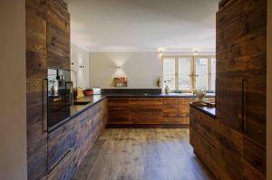 a large kitchen with wooden cabinets and a window at Kitz-Chalet in Kitzbühel