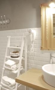 baño con lavabo blanco y estante con toallas en Trastevere Residence, en Roma