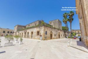 een oud stenen gebouw met palmbomen in een straat bij Casa Mario vista mare in Torre Santa Sabina