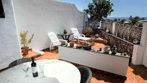 a patio with white tables and chairs and a fence at Casa CHARCO 5 in Charco del Palo