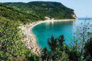 a beach with a bunch of people in the water at Camping Village Internazionale in Sirolo
