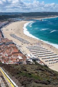 an aerial view of a beach with umbrellas and the ocean at SeetheSea in Nazaré