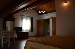 Schlafzimmer mit einem Bett, einem Tisch und einem Fenster in der Unterkunft Agriturismo Alla Corte in Vicenza