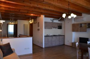 a kitchen and a living room with wooden ceilings at Agriturismo Alla Corte in Vicenza