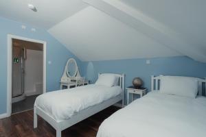 two beds in a room with blue walls at The Oak Baginton in Coventry