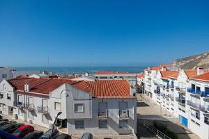 uitzicht op een stad met gebouwen en de oceaan bij SeetheSea in Nazaré