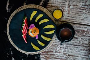 a plate of food with fruit on a table at Éteka Slow Beach Hotel in Cartagena de Indias