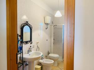 a bathroom with a sink and a toilet and a mirror at Residenza Arene in Gallipoli