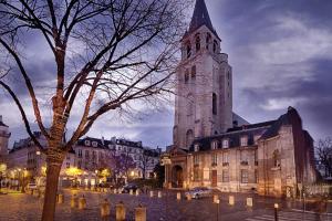 eine große Kirche mit einem Uhrturm in einer Stadt in der Unterkunft Luxe Atelier bail mobilité Saint germain des Près in Paris