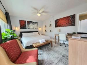 um quarto com uma cama, um sofá e uma mesa em Barefoot mailman motel em Lantana