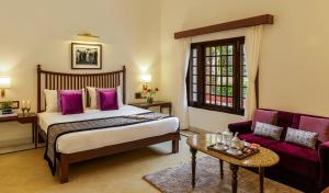 a bedroom with a bed and a couch and a table at Jehan Numa Palace Hotel in Bhopal