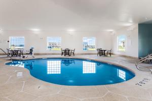 una piscina en una habitación con mesas y sillas en Sleep Inn North Liberty/Coralville, en North Liberty