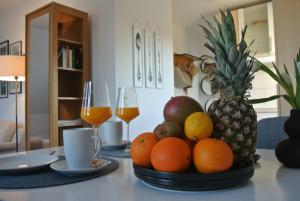 a bowl of fruit on a table with two glasses of wine at FischLANDinSicht in Ribnitz-Damgarten