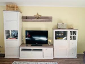 a living room with a tv and white entertainment centers at Eine charmante Wohnung wartet auf Sie in Alzenau in Unterfranken