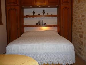 1 dormitorio con 1 cama blanca y armarios de madera en Studio 2 personnes, en Pechpialat