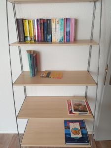 a book shelf with books and a book at Mornag AG Ferien Wohnung in Weesen