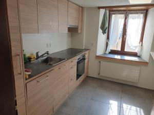 a kitchen with wooden cabinets and a sink and a window at "VILLA HI" Wohnung Parkplatz inbegriffen in Weesen