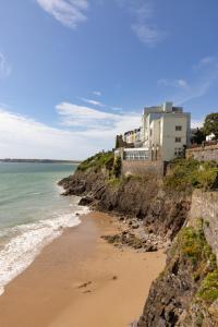 a house on a cliff next to a beach at Imperial Hotel Tenby in Tenby