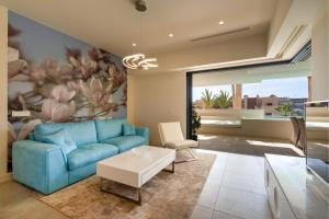 a living room with a blue couch and a flower mural at Holiday Apartment Azalea La Cala in La Cala de Mijas