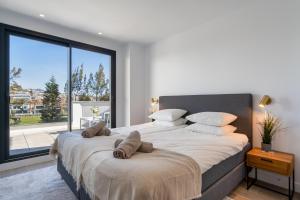 a bedroom with a large bed with a large window at Holiday Apartment Navigolf La Cala in La Cala de Mijas
