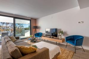 a living room with a couch and blue chairs at Holiday Apartment Navigolf La Cala in La Cala de Mijas