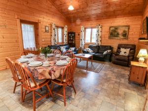 a large living room with a table and chairs at Chloe's Lodge in Pickering