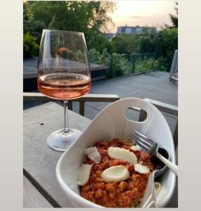 eine Schüssel mit Essen neben einem Glas Wein in der Unterkunft Bochum ich komm aus Dir! in Bochum