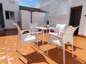 コニル・デ・ラ・フロンテーラにあるCasa Chaniの白い椅子とワイン1本