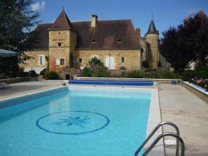 a large swimming pool in front of a castle at Gîte dans propriété périgourdine in Pechpialat