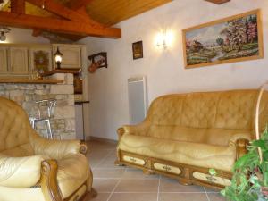 a living room with two leather couches and a fireplace at Gîte dans propriété périgourdine in Pechpialat